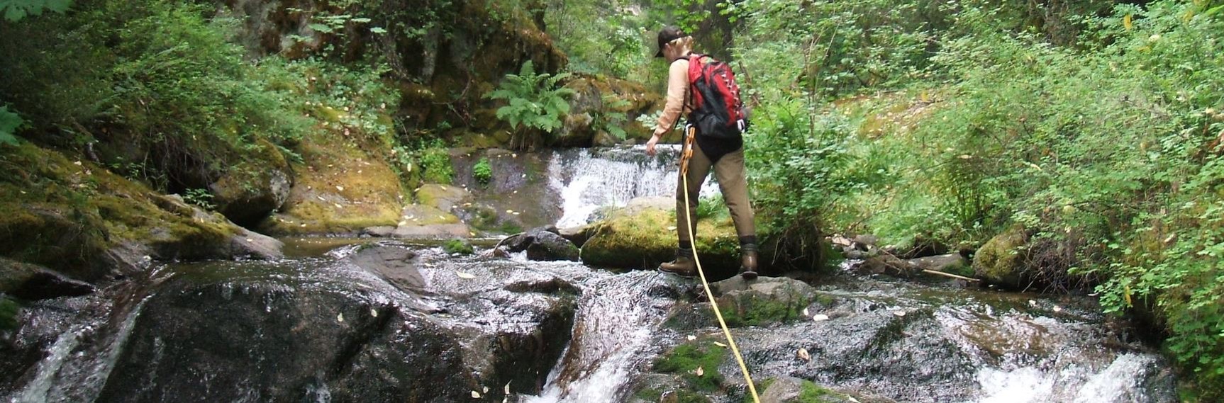 A surveyor measures a cascade